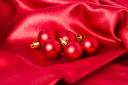 红色丝绸布上的红色圣诞球图片