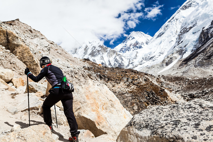 在尼泊尔喜马拉雅山脉的人行道上行走的北欧女徒步旅行者在秋季自然的岩石小径上徒步前往珠穆朗玛峰大本营图片