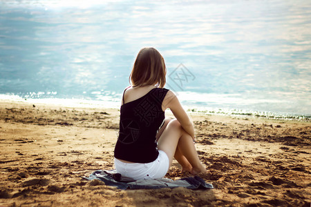 放松在海滩的孤独的女孩图片