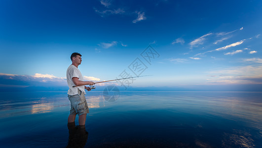 日落时在海滩上钓鱼的渔人带图片