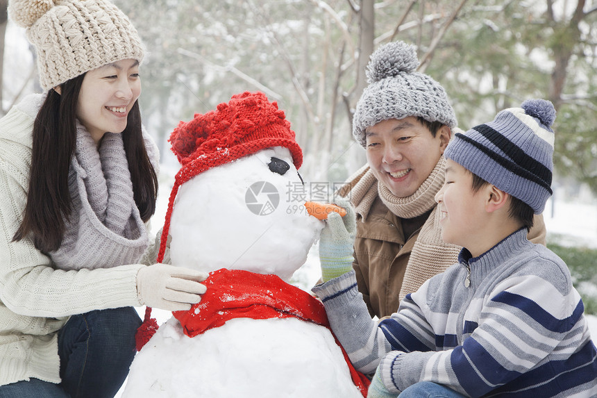 冬天在公园里堆雪人的家庭图片