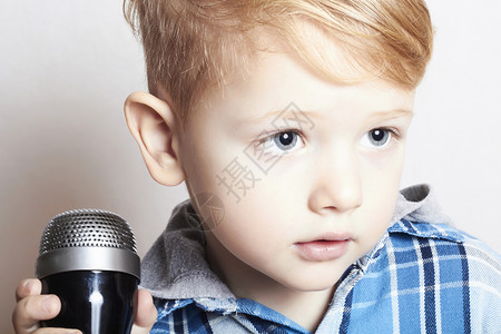 小男孩在麦克风中歌唱图片