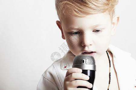 小男孩在麦克风里唱歌小孩在背景图片