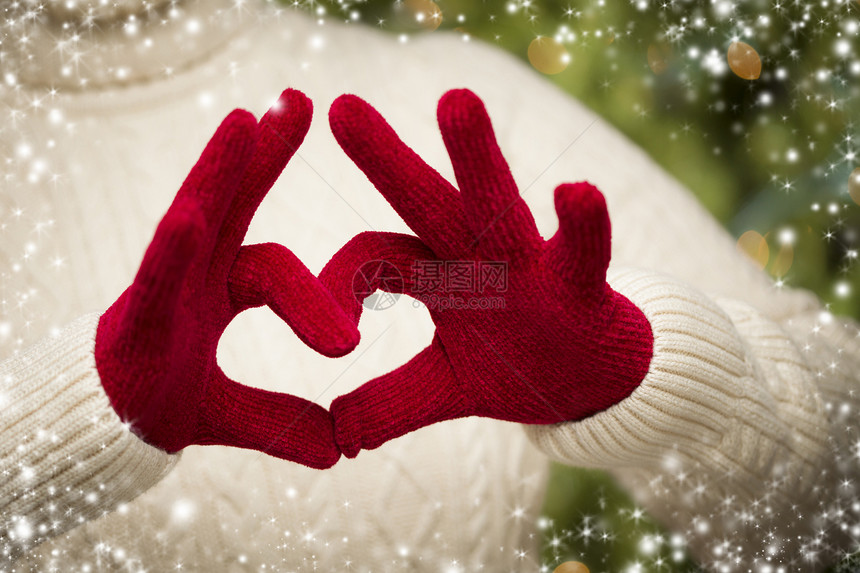 穿着季节红手套穿泳衣的女人用她的手握着一个心牌图片