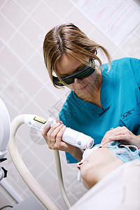 果酸焕肤患者正在接受由年轻女临床医生进行的激光焕肤治疗背景