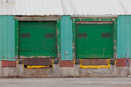 两扇绿色油漆的百叶窗门装入预制金属封装图片