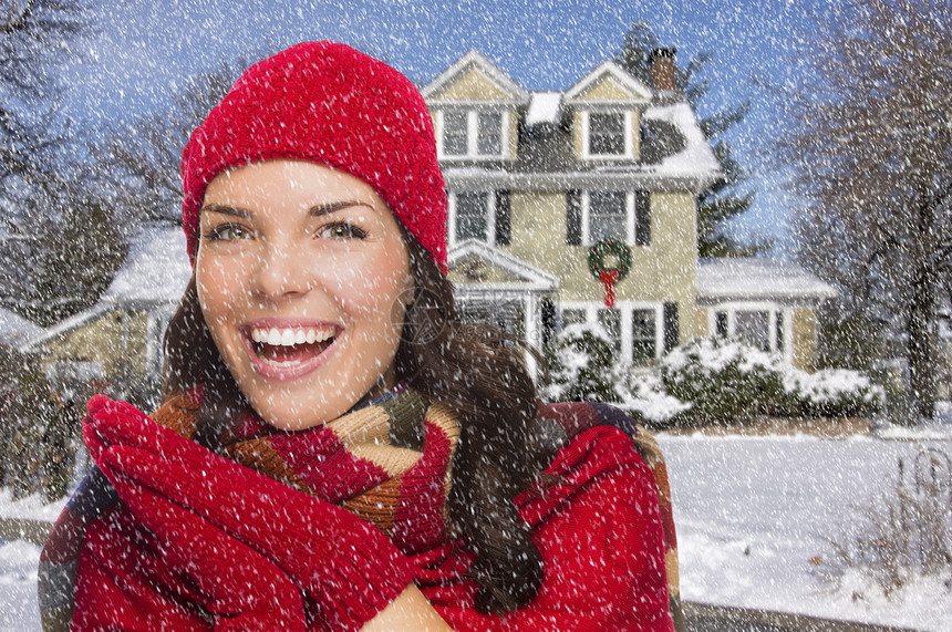 在落雪之屋外的冬季装扮中微笑的混合种图片