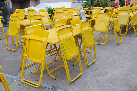 许多带折叠椅的黄色钢桌套装图片