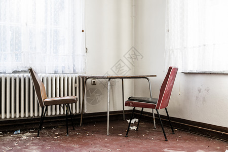 空桌和两张椅子都放在一个房间的角落背景图片