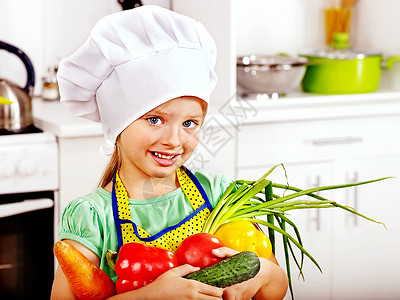 孩子在厨房里拿着蔬菜图片