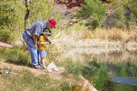 爷带着孙子在美丽的湖边钓鱼图片