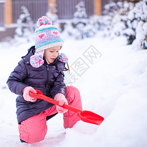 小女孩在冬日里玩铲雪背景图片