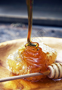 美味的蜂蜜蜂蜜迪珀和蜜蜂窝在木板上背景