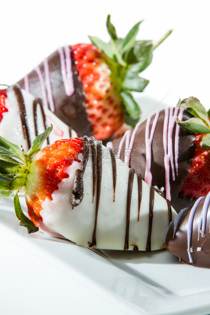 巧克力覆盖的草莓与白色和深色巧克力密闭在白图片
