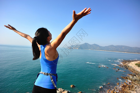 远足妇女站在海边的山岩图片