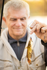 高级渔夫把鱼挂在钩子上背景图片