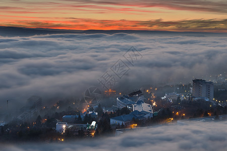 透过薄雾和云层可见的傍晚城市图片