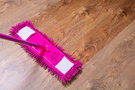 用湿粉红色拖把清洁镶木地板前后图片
