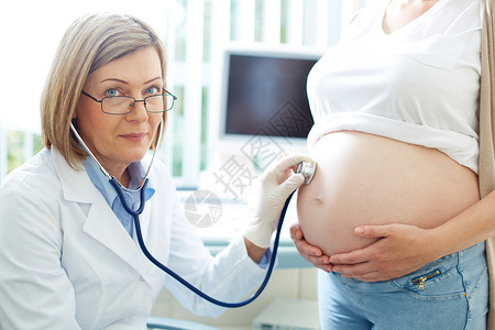 在检查怀孕年轻孕妇的肚子时图片