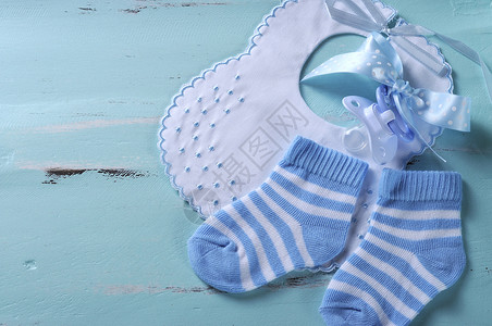 男婴幼儿园蓝色和白色袜子围兜和假奶嘴图片