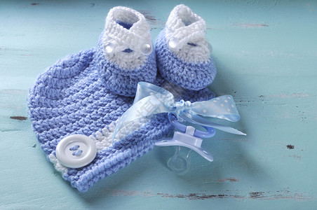 男婴幼儿园蓝色和白色羊毛短靴假人奶嘴和帽子图片