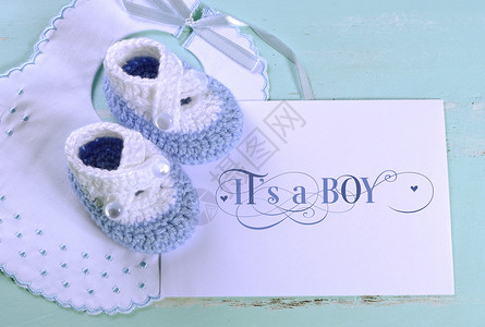 男婴幼儿园蓝色和白色羊毛短靴围兜和卡片图片