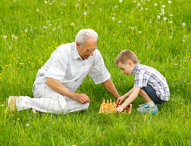 在草地上的草地上下棋的爷和孙子图片