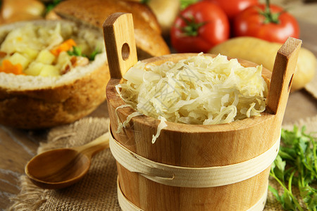 木桶里的酸菜和背景中的白菜汤图片