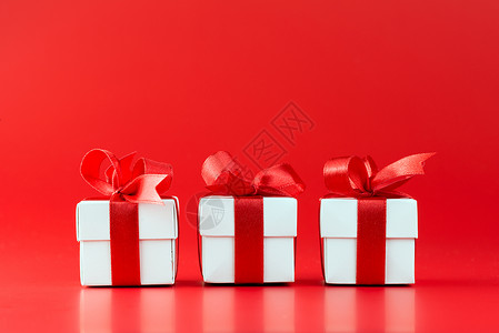 三个白色礼物盒红背景图片