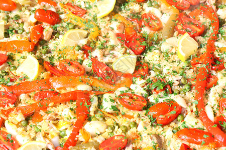 巴伦西亚海鲜饭配米饭豌豆和红番茄的背景图片