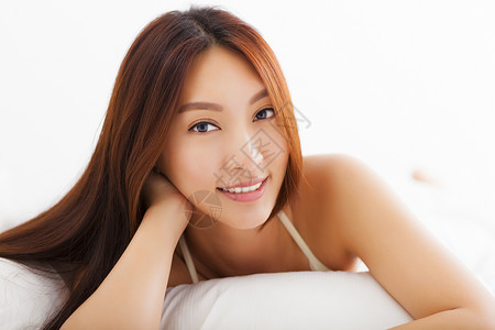 年轻美丽的亚洲女子在床图片