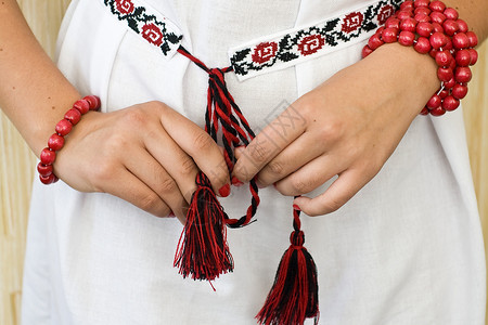 带红色手镯和传统刺绣衬衫的女孩的手图片