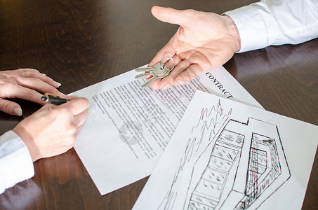 显示房屋钥匙和妇女签订房地产合同的不图片