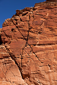 X峡谷内一个陡峭的橙色沙石悬崖里面有一颗X的图片