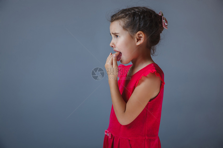 女孩用灰色背景的红礼服在他的嘴里图片