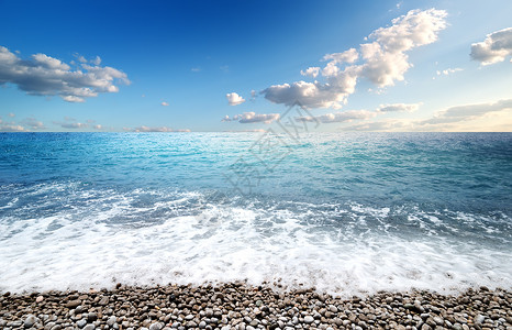 日出时的大海和卵石滩图片