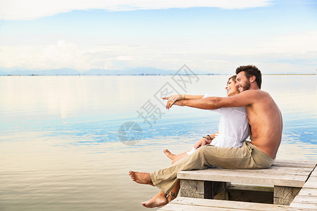 男人和女人情侣坐在堤防上指着蓝图片