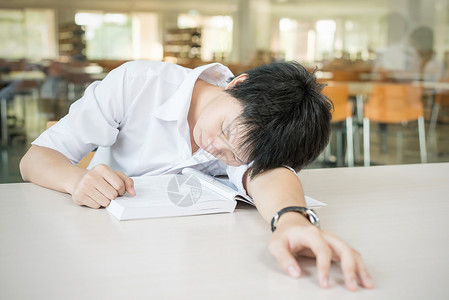 亚洲学生躺在课桌上睡觉图片