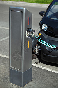 带电源的汽车通过充电缆连接到柱子上高清图片