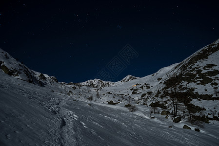 美丽的星空和由月亮柔光照耀的山地风雪图片