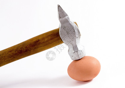 一个银锤头近距离击中一个完整的鸡蛋背景图片