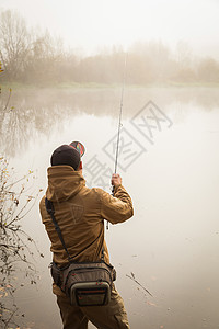 秋天背景的渔夫他手里拿着纺纱的渔夫图片