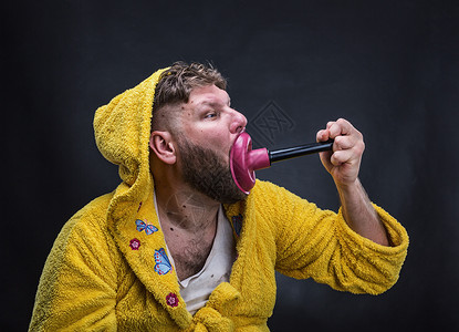 穿着毛圈浴袍的陌生人正在用空气阀清洁他的嘴图片
