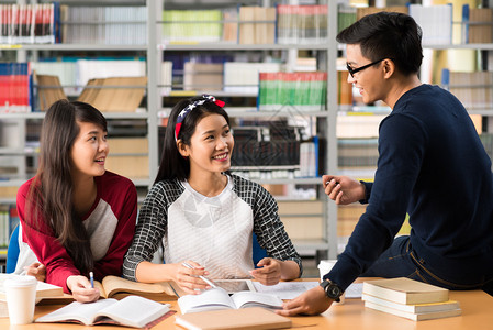 亚裔大学生在图书馆做功课图片