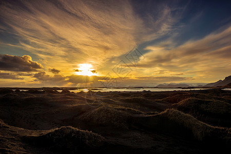 冰岛斯托克斯内海边火山熔岩沙丘上的日落图片