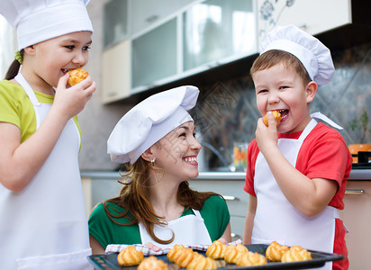 母亲和幸福的孩子在厨房做面包图片