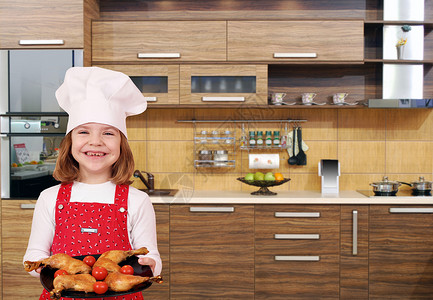 小女孩在厨房里用鸡腿做饭图片