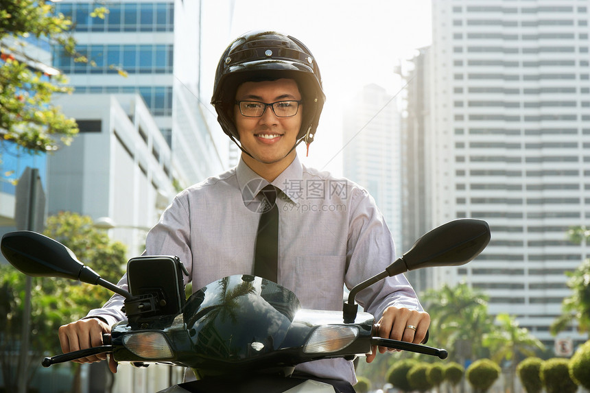 年轻的亚洲商人通勤上班该男子骑着一辆带白色头盔的摩托车图片