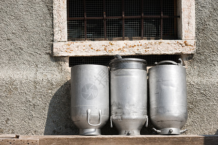 三个用铝制成的老牛奶罐在图片