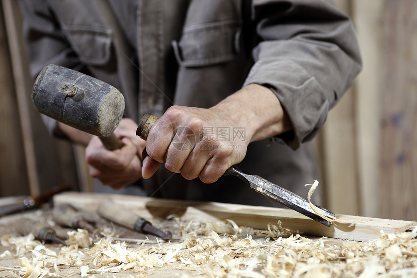 木匠的手用锤子和铲子敲图片